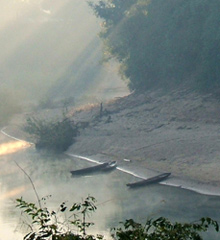 Wooden paddle boats on sand beach, river in Laos southern hills